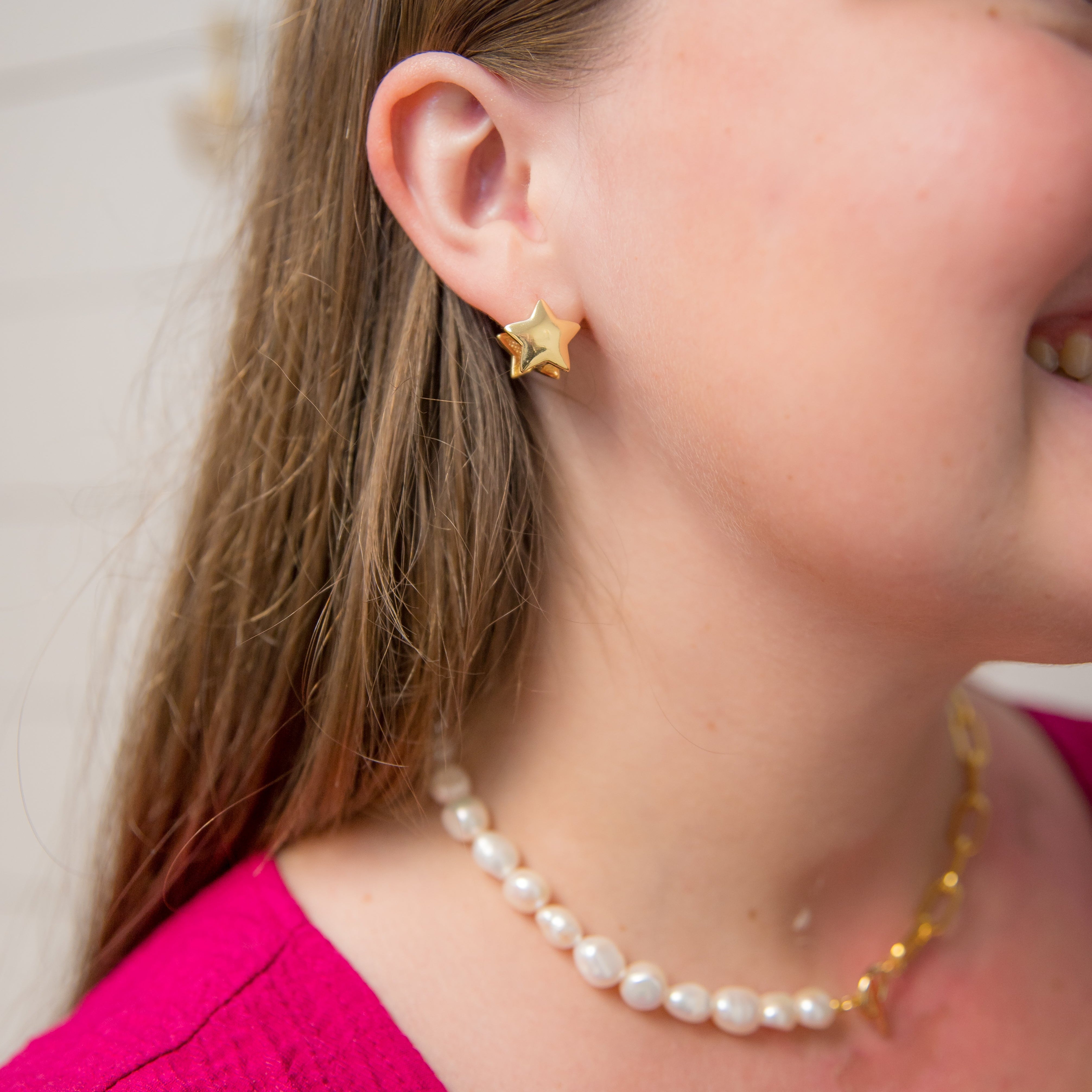 Person wearing a double star huggies earring
