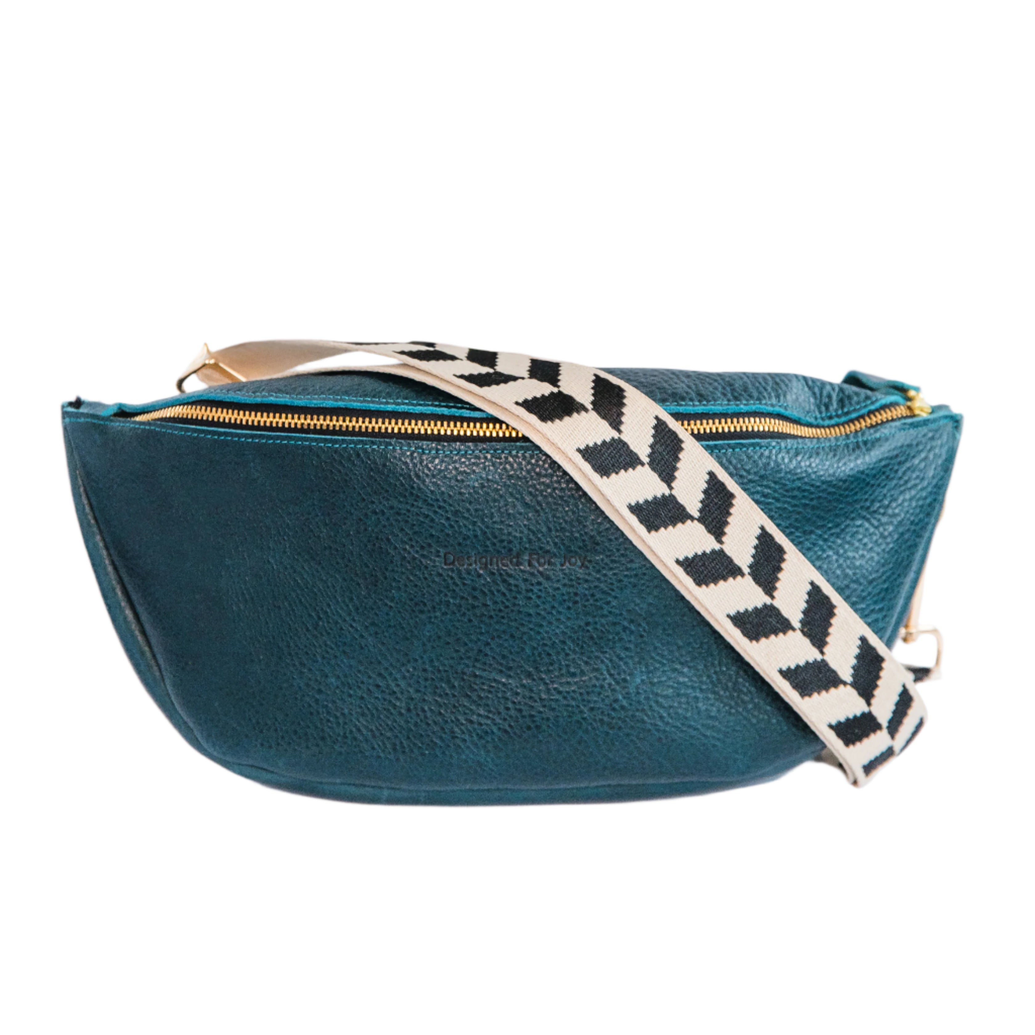 Teal crossbody sling handbag with a black and white geometric patterned strap on a white background