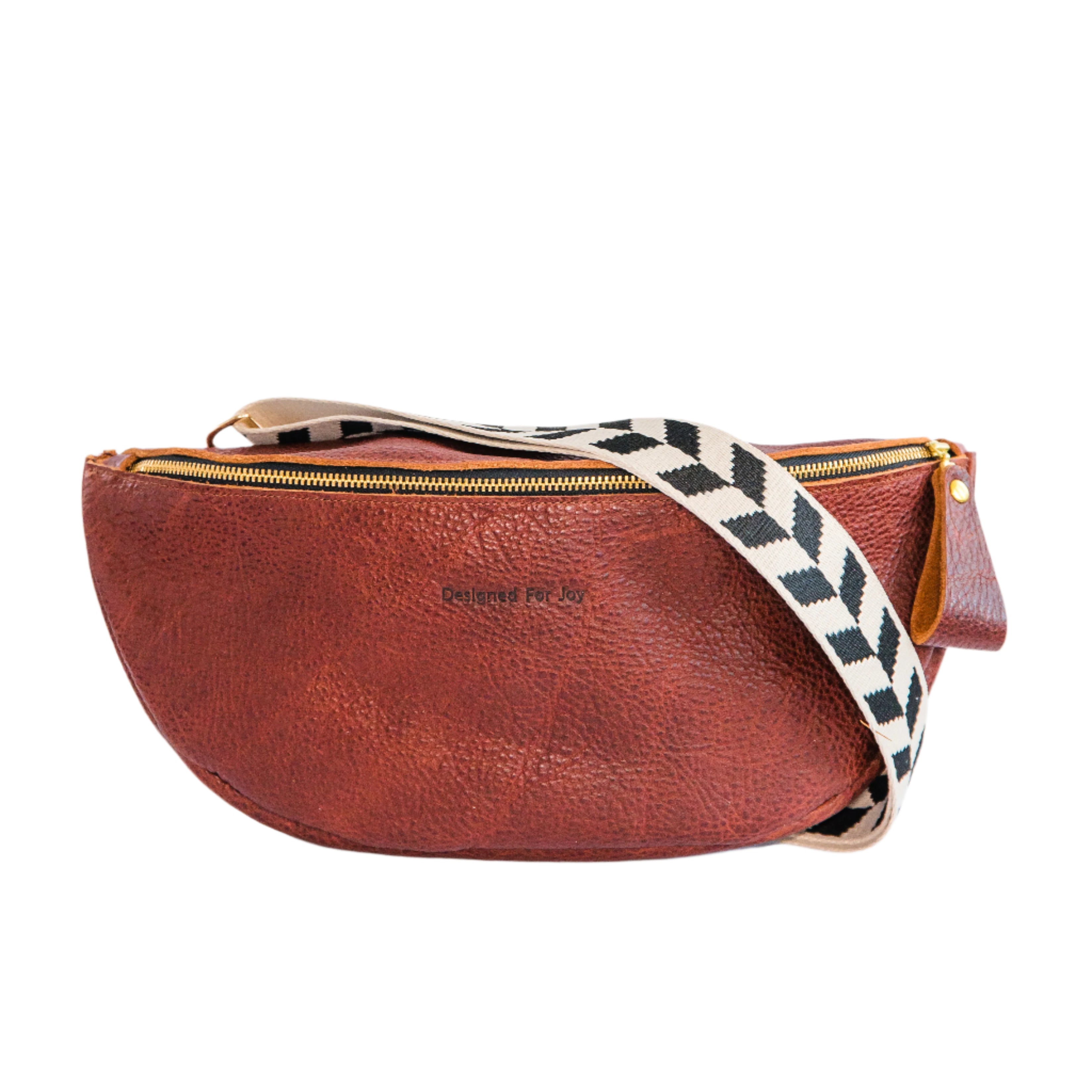 Cinnamon brown crossbody sling handbag with a black and white geometric patterned strap on a white background