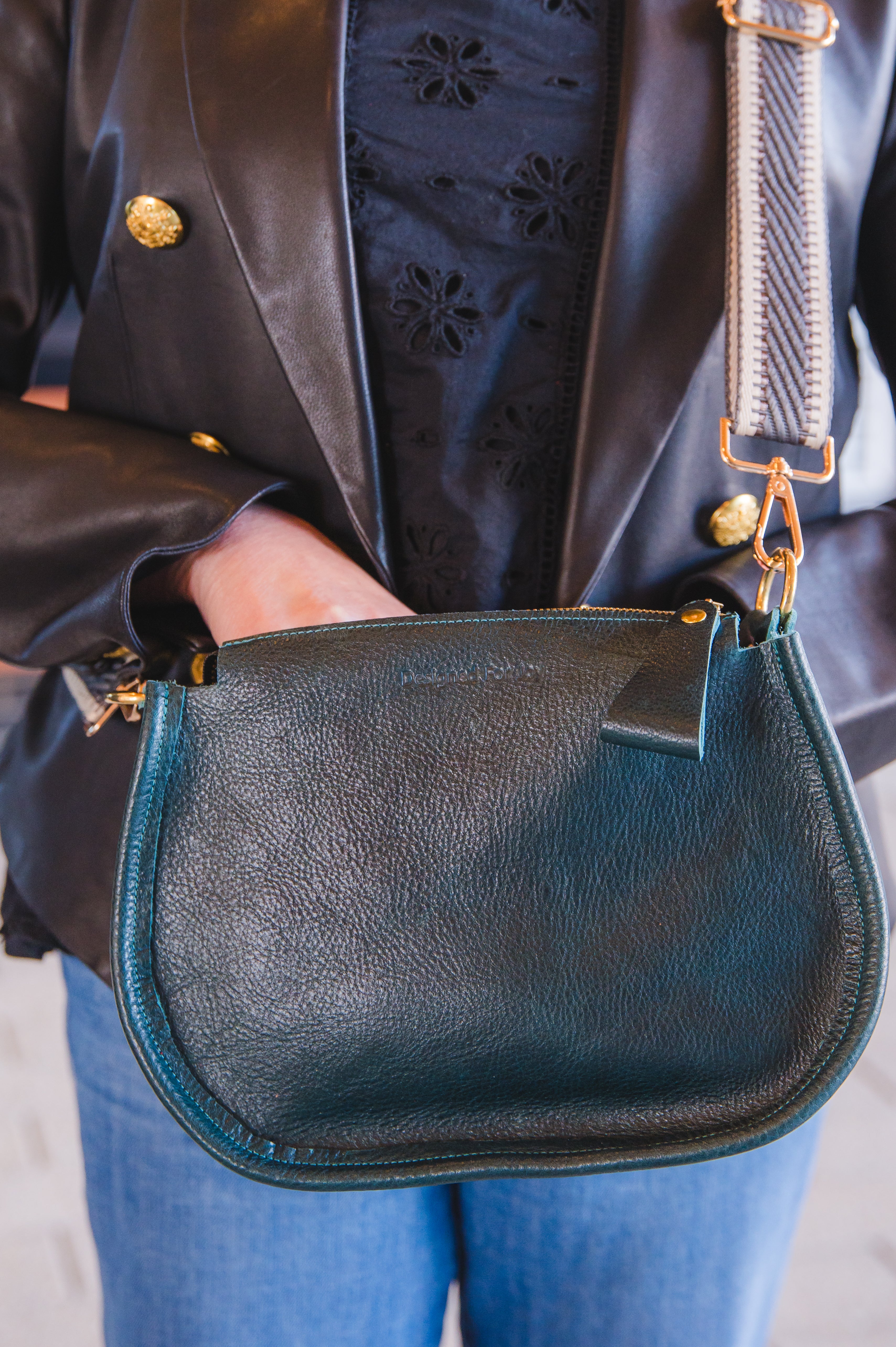 Close up of a person wearing a black crossbody handbag