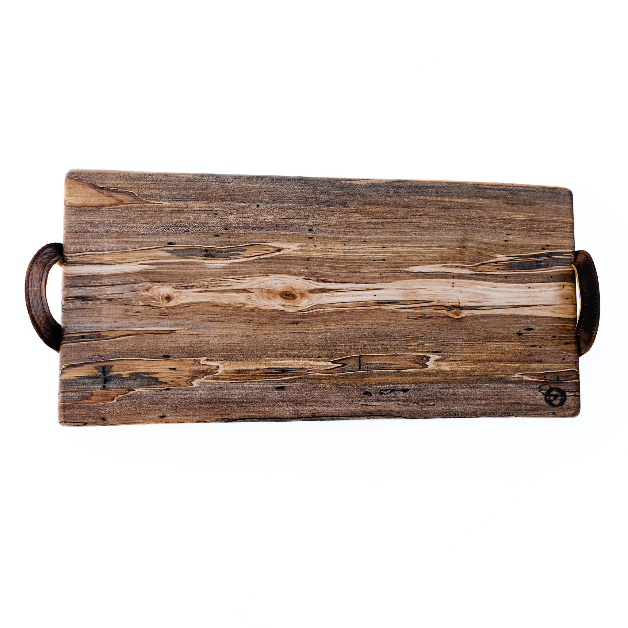 A live-edge charcuterie board made of black walnut wood with leather handles