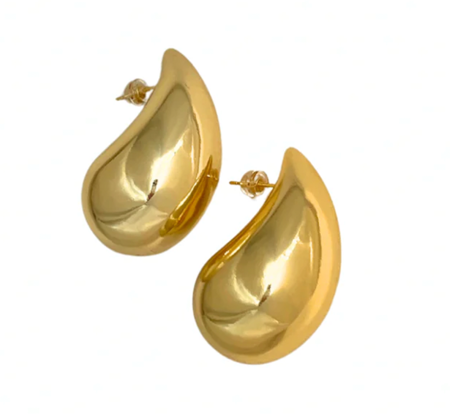 Pair of gold puffy teardrop earrings on their side, on a white background