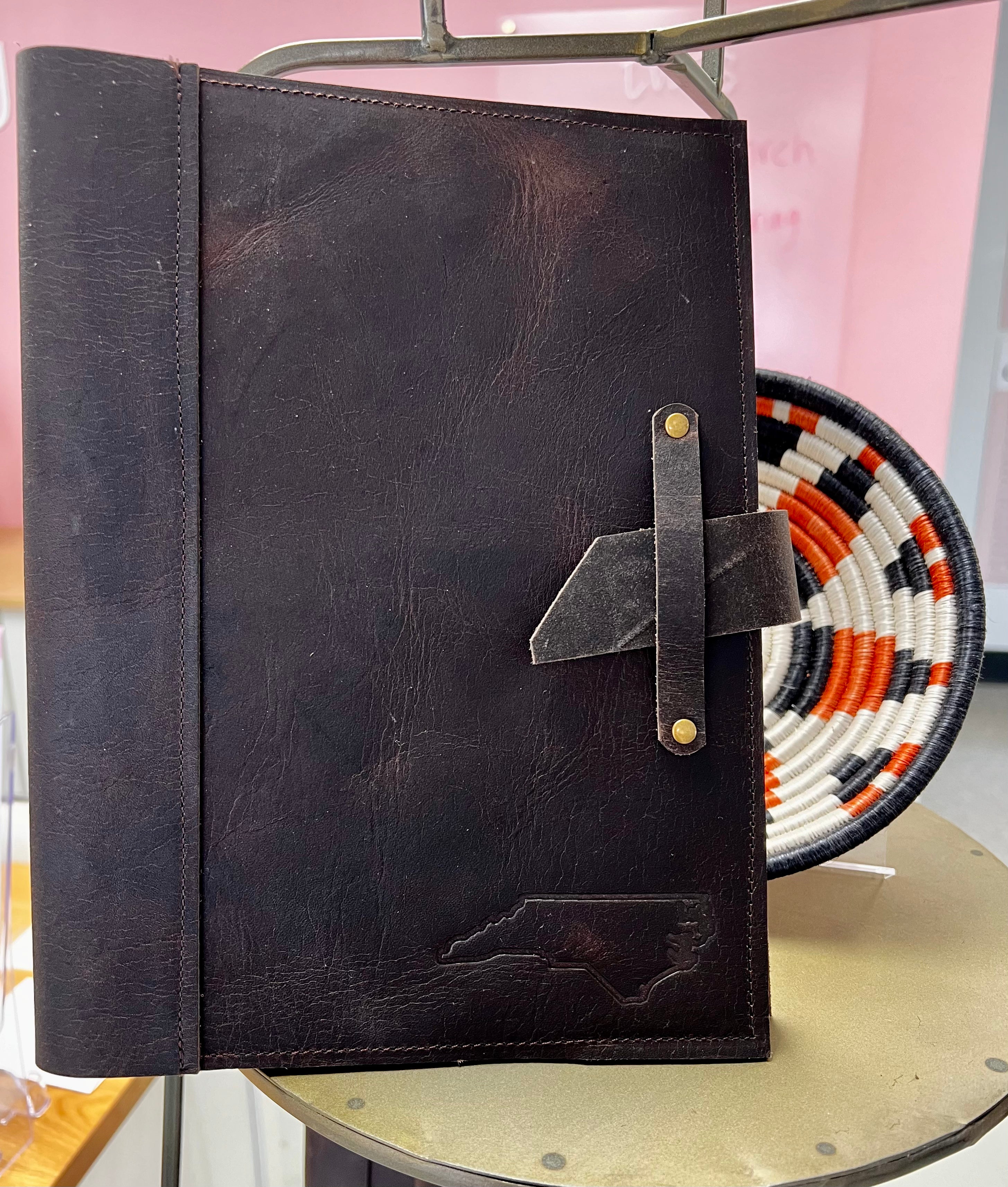 A brown leather journal displayed in a vertical orientation