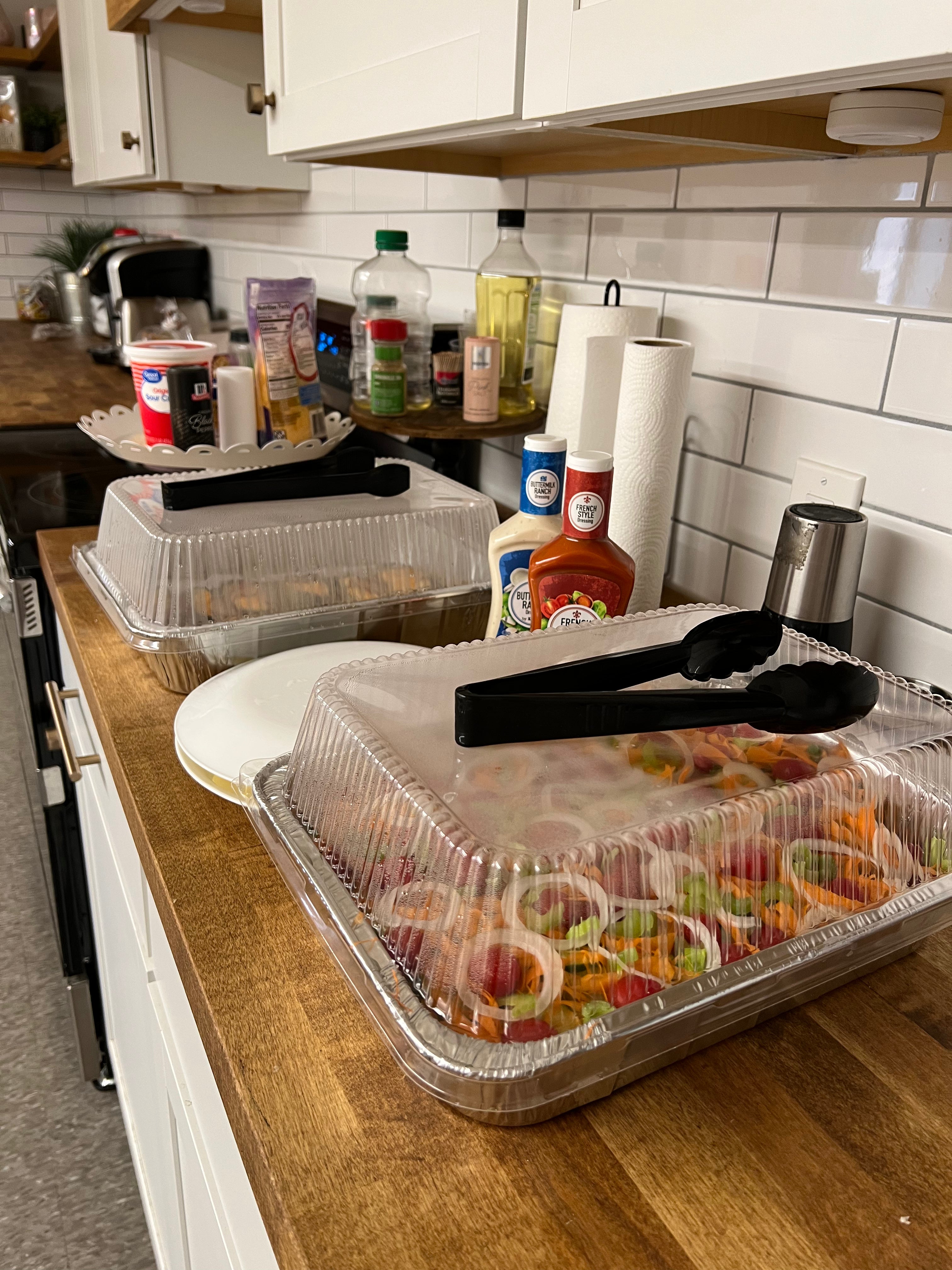 Image of a kitchen countertop with trays of food on top of it
