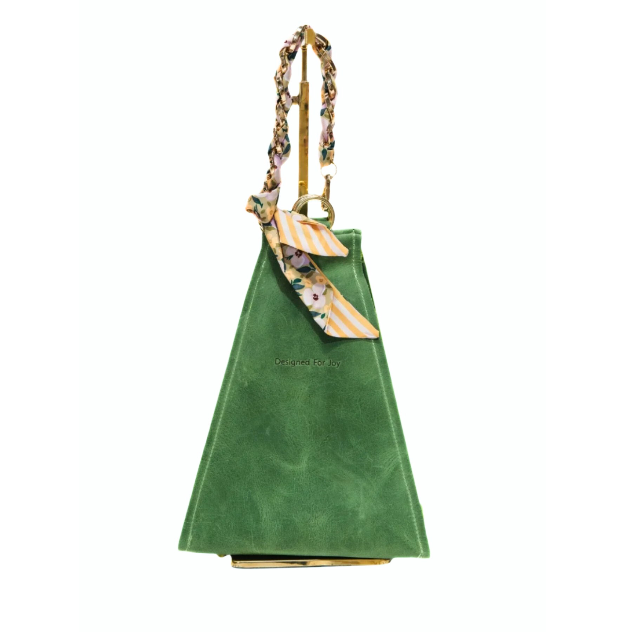 Evergreen bucket handbag with a gold chain wrist strap that has a removable scarf and 'Designed for Joy' text, displayed on a white background
