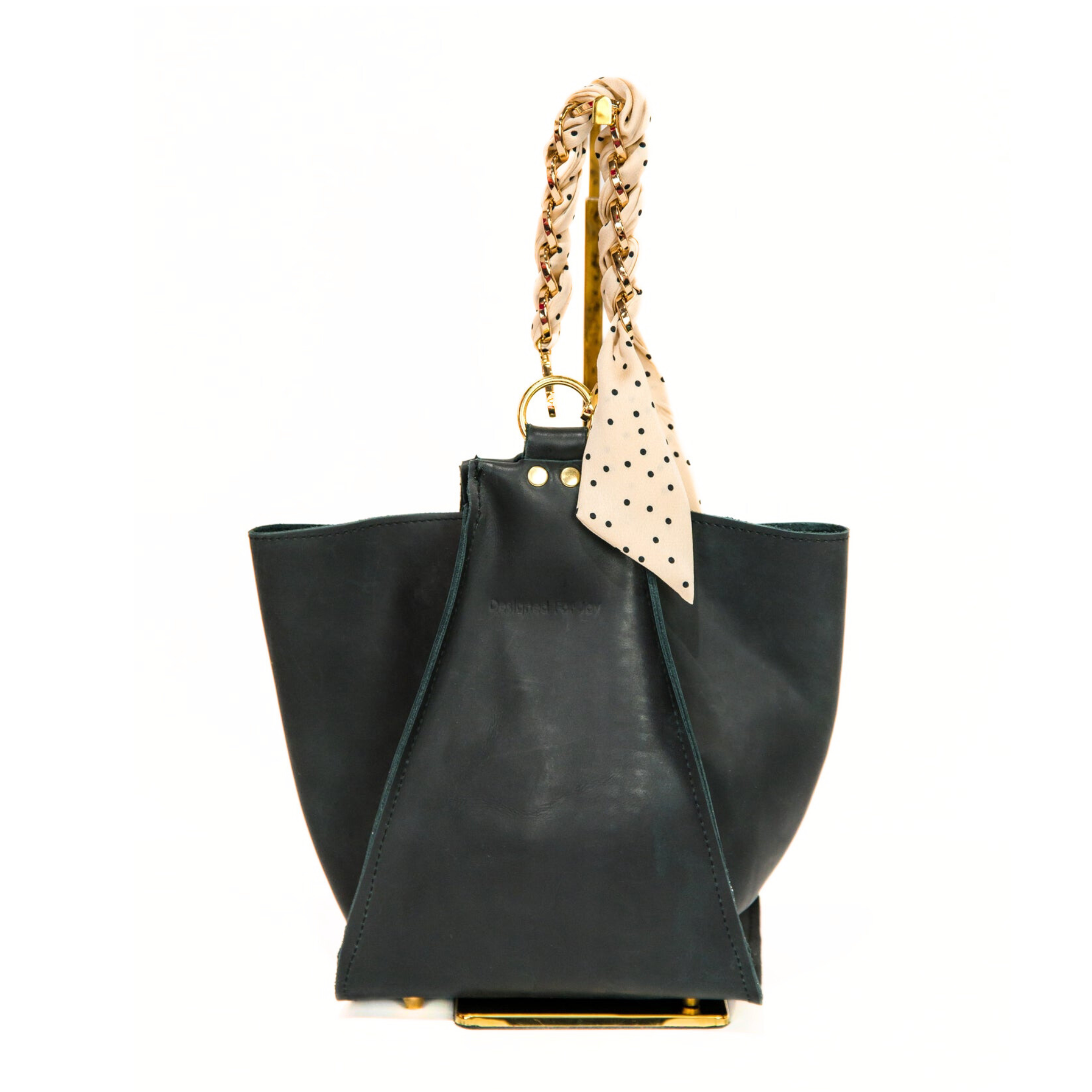 Black bucket handbag with its pockets folded out to the side, displayed on a white background