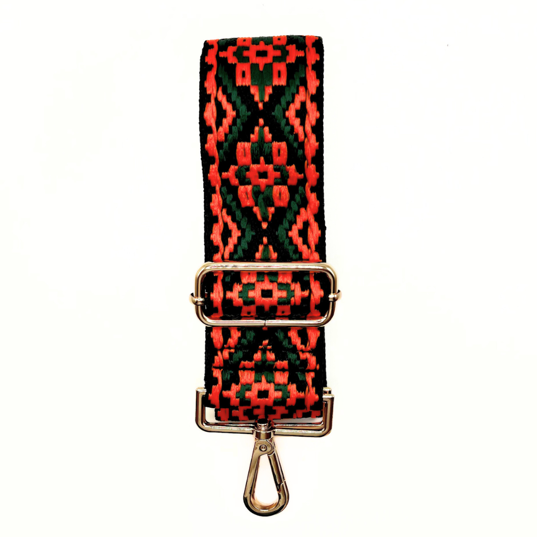Red and dark green adjustable crossbody strap with a geometric pattern and metal hardware, displayed on a white background