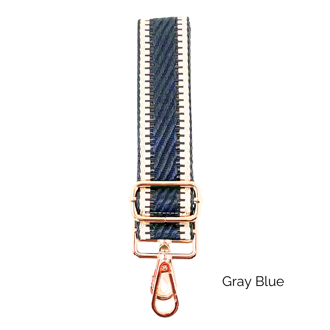Gray blue crossbody strap with metallic thread details and gold hardware on a white background