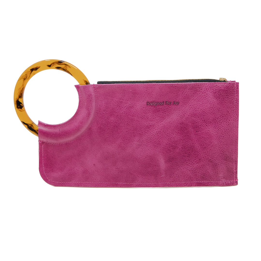 Pink wristlet handbag with smooth resin handle and chunky zipper closure on a white background