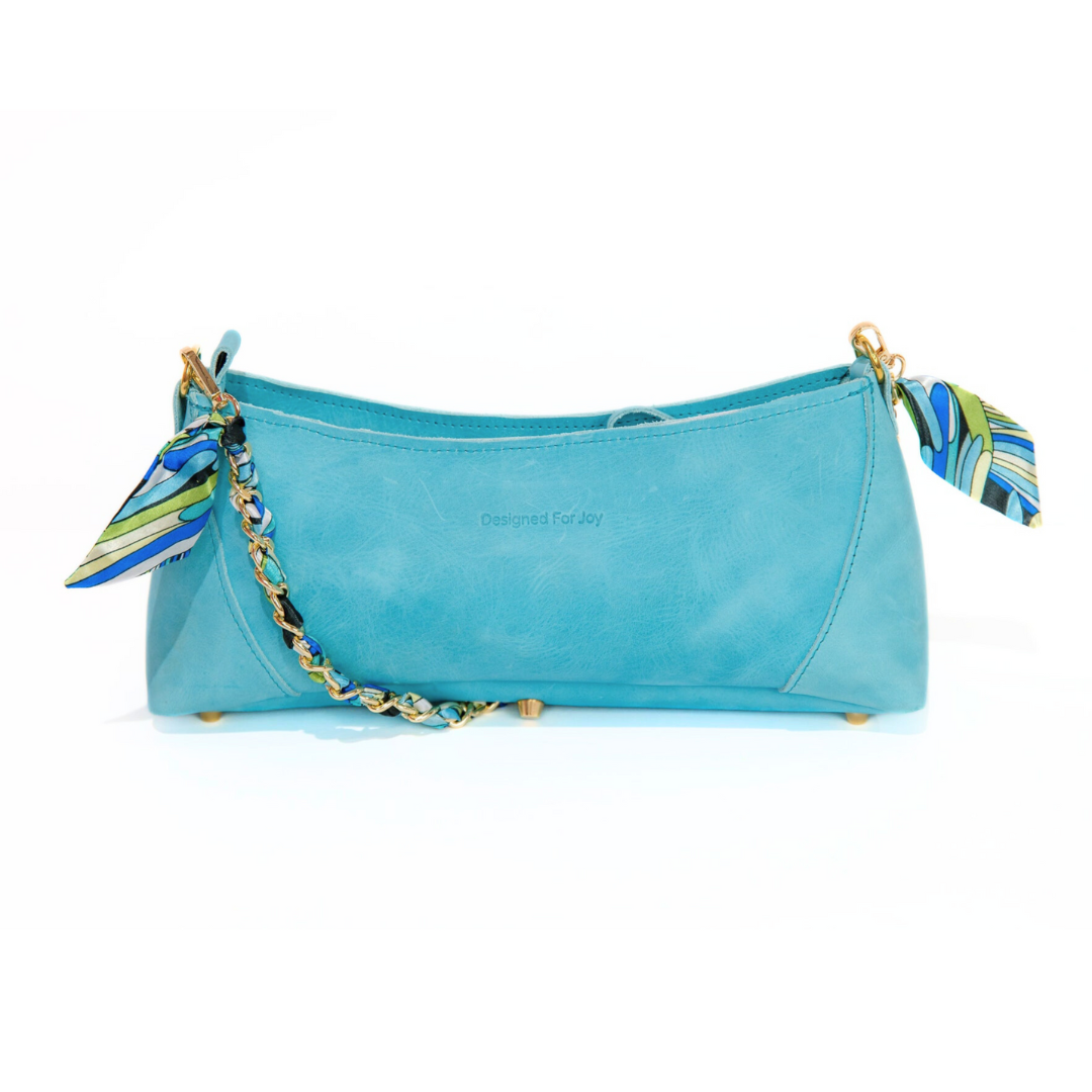 Aqua blue leather shoulder handbag with a gold-tone chain shoulder strap and a satin scarf woven through the it, displayed on a white background