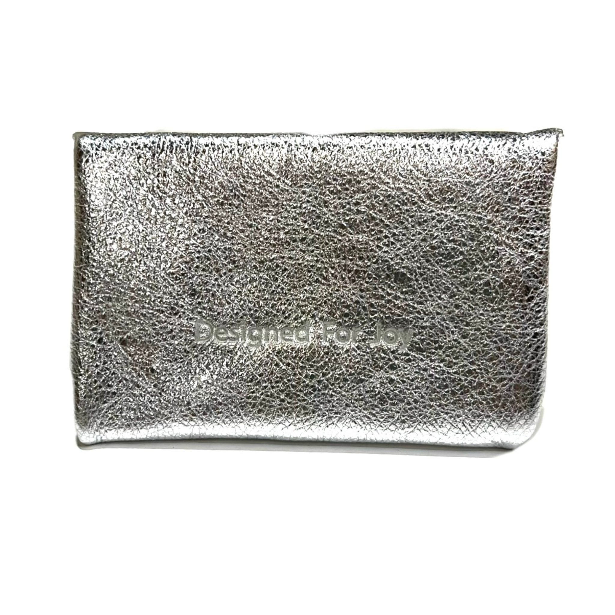 Back of a silver metallic button stud coin purse with the text 'Designed for Joy' embossed on it