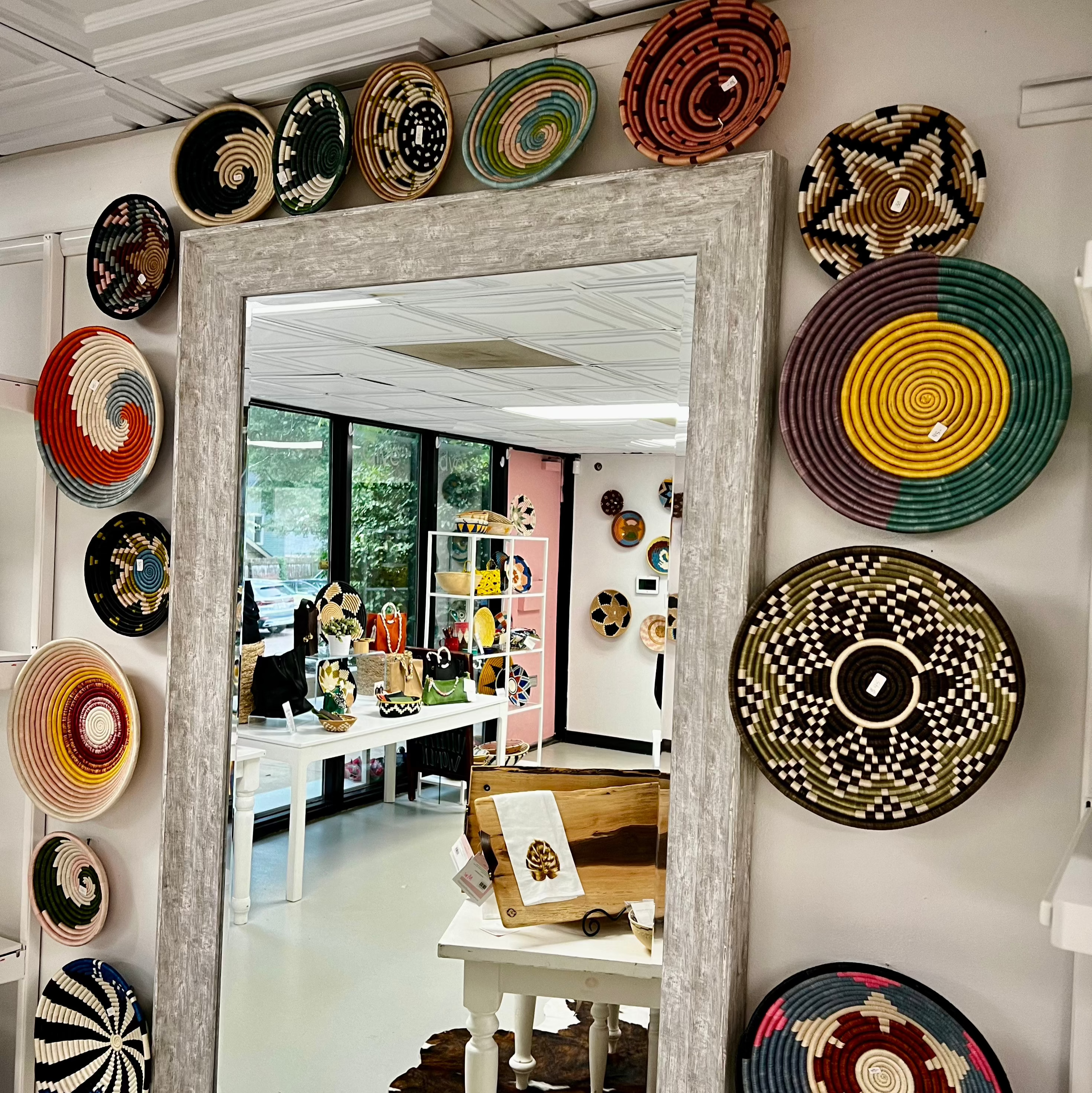 Colorful Rwandan baskets displayed around a mirror inside a boutique