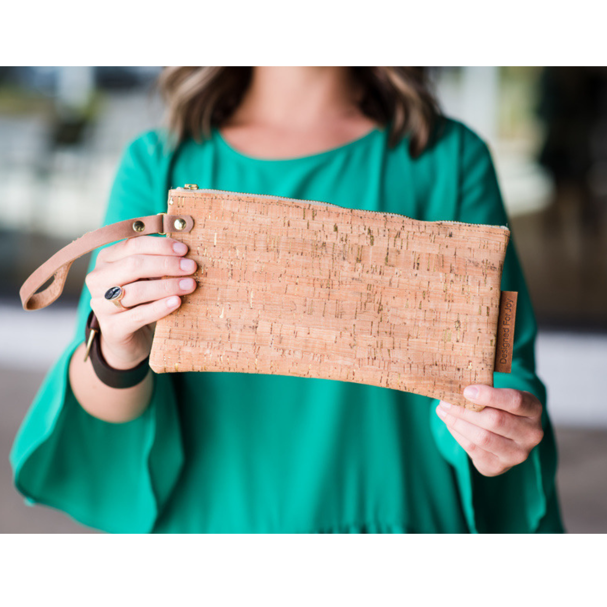 A person holding out a cork wristlet while the background is blurred