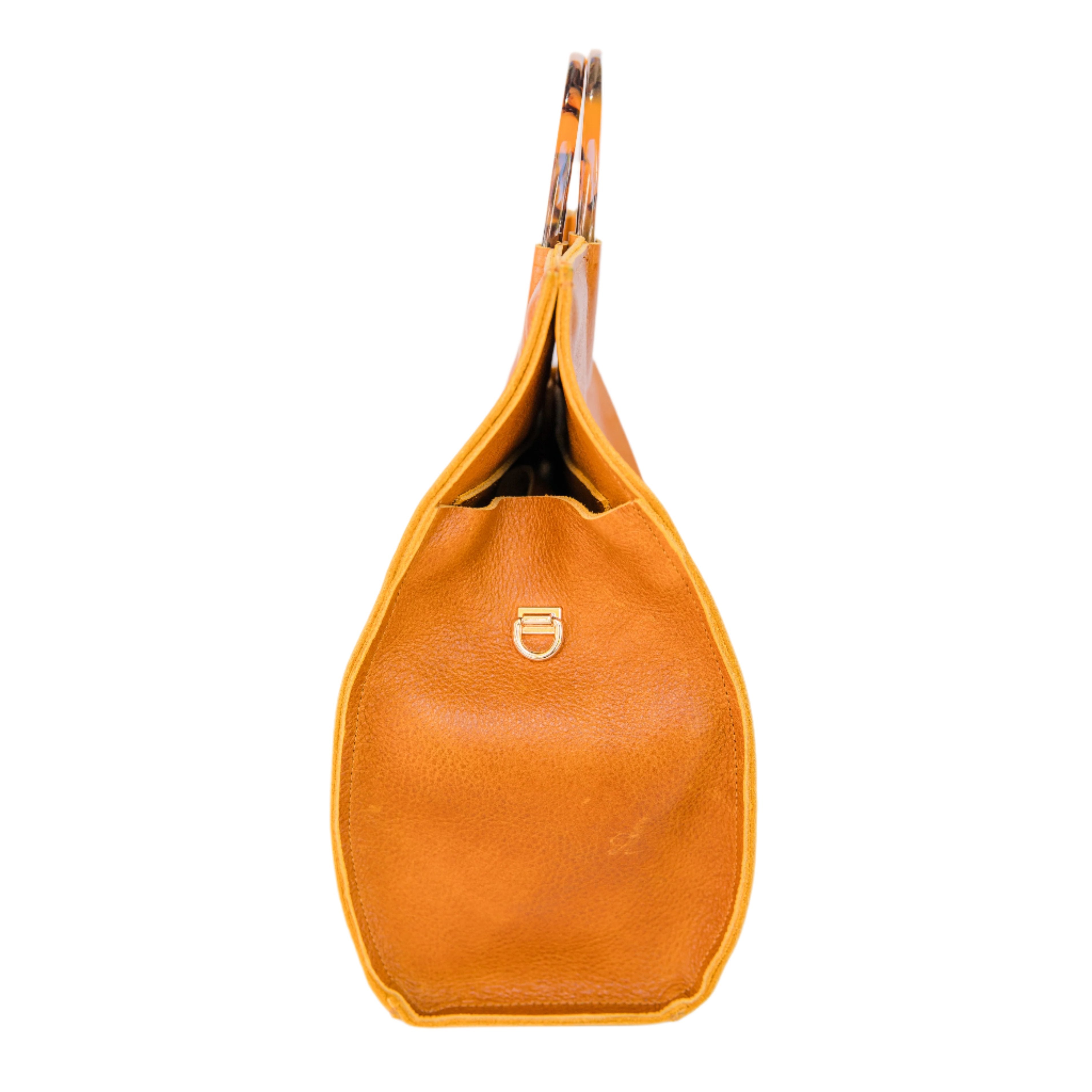 Side angle of a caramel brown satchel handbag displayed on a white background