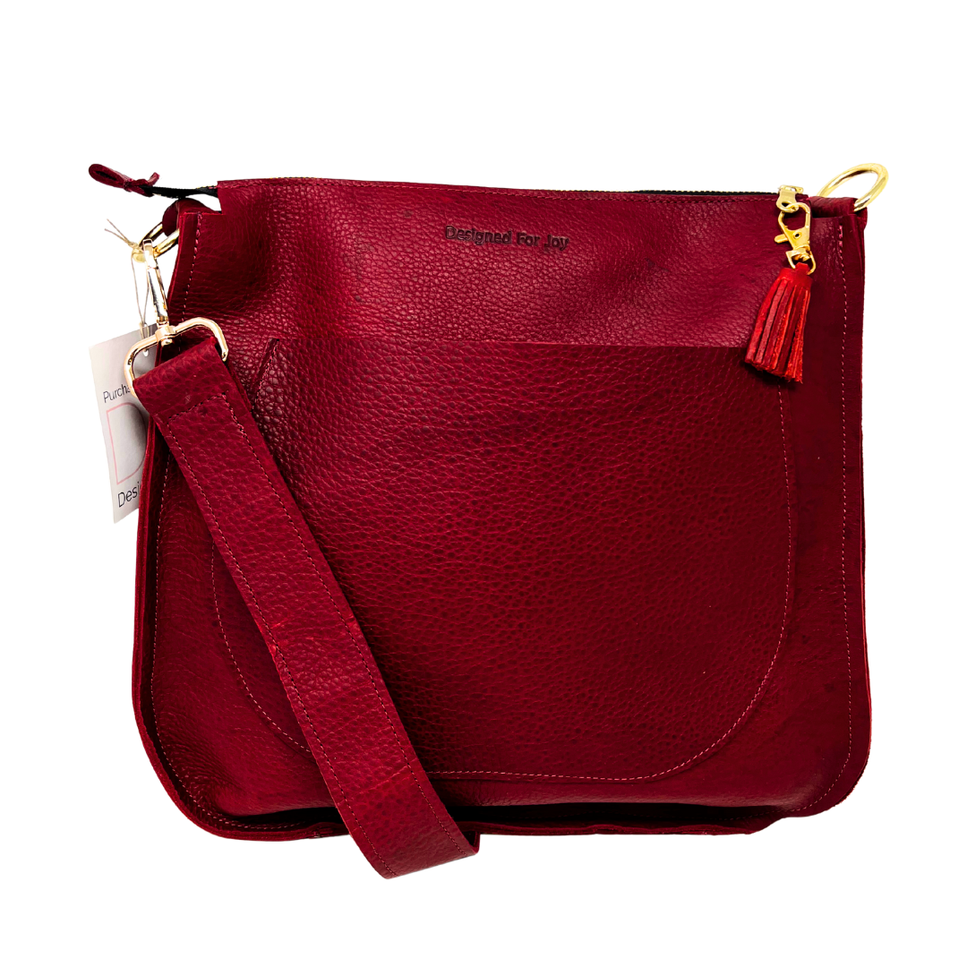 Red leather bag with a red strap and tassel on a white background