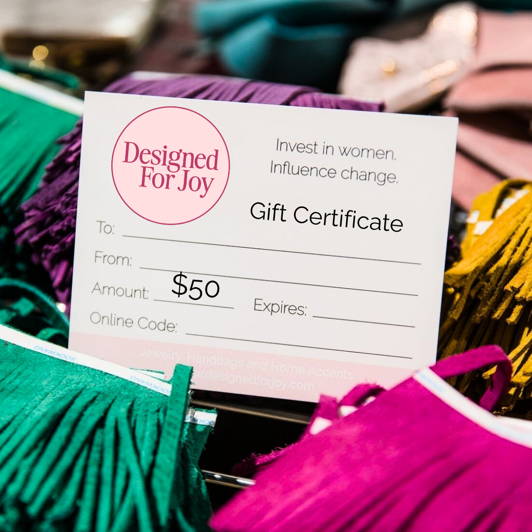 Gift certificate for 'Designed For Joy' for an amount of $50, displayed on colorful fringe accessories