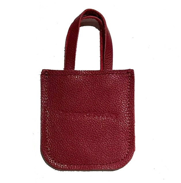 Red leather mini tote bag displayed on a white background