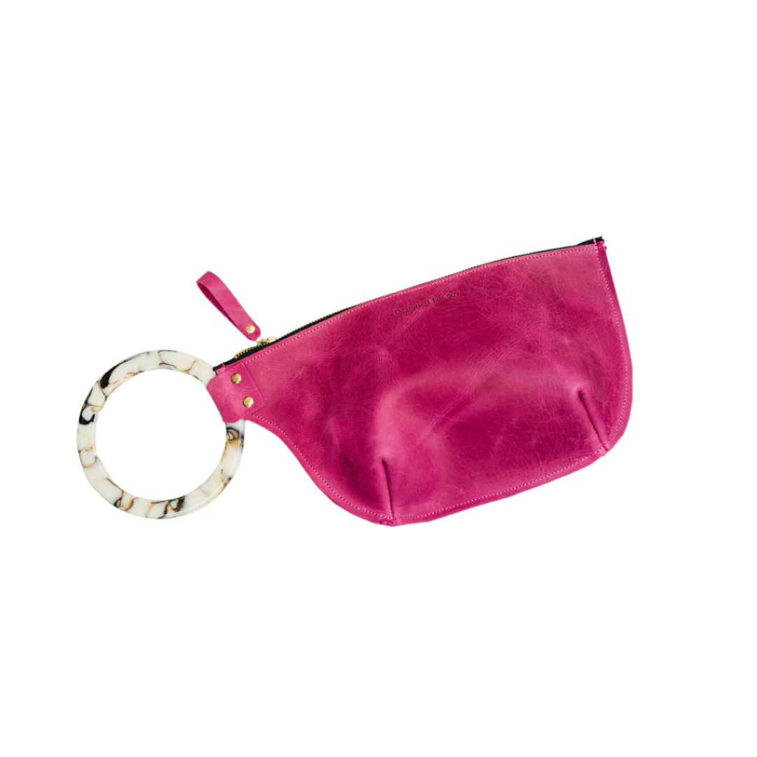 Raspberry pink wristlet handbag with a smooth resin handle and a zippered compartment, displayed on a white background