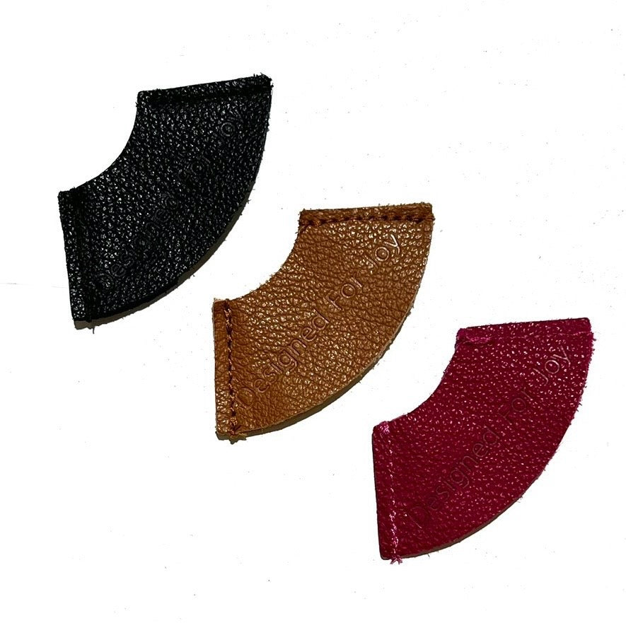 Three leather bookmarks in black, brown, and red