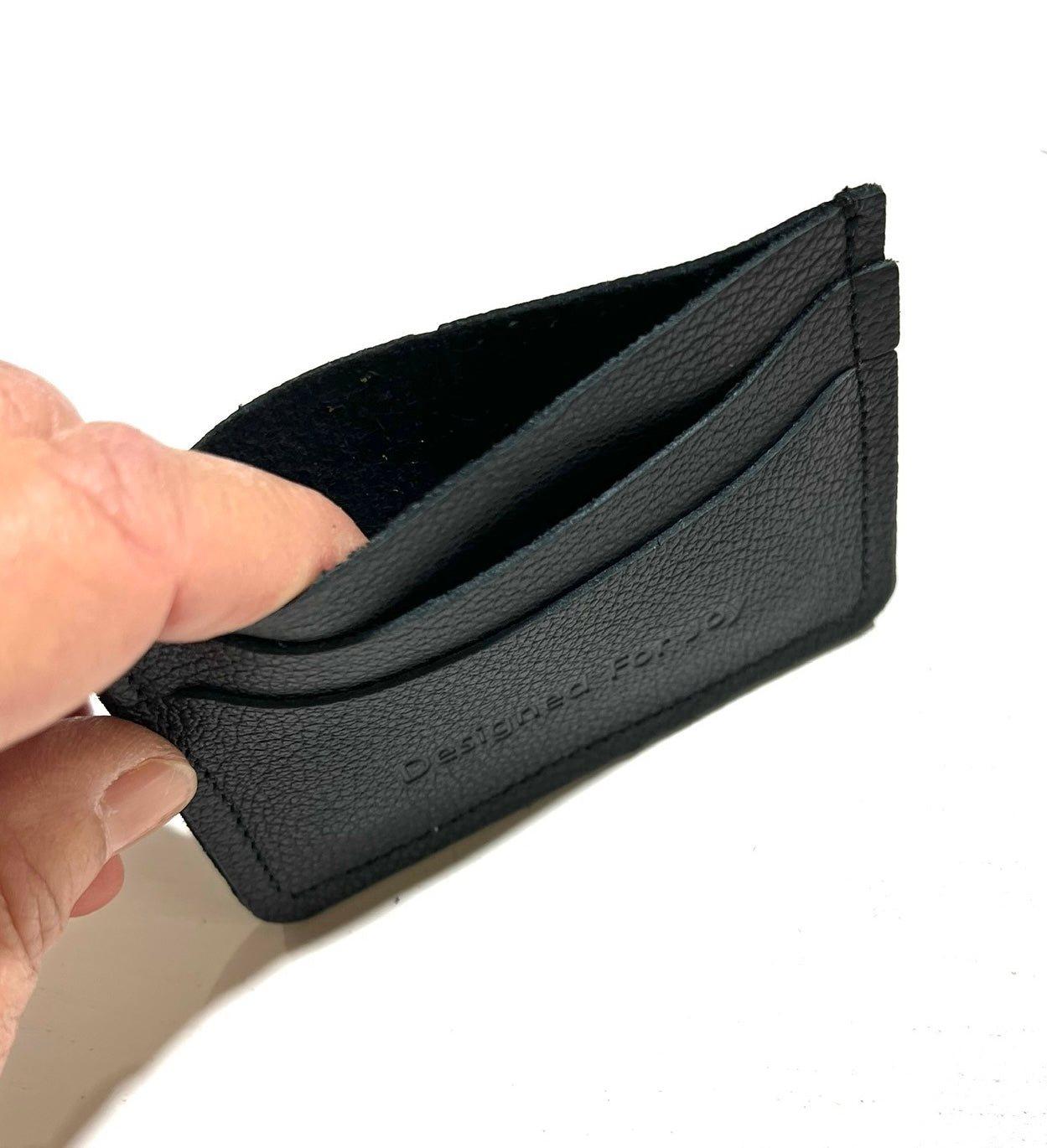 Black leather credit card wallet being opened up by a hand