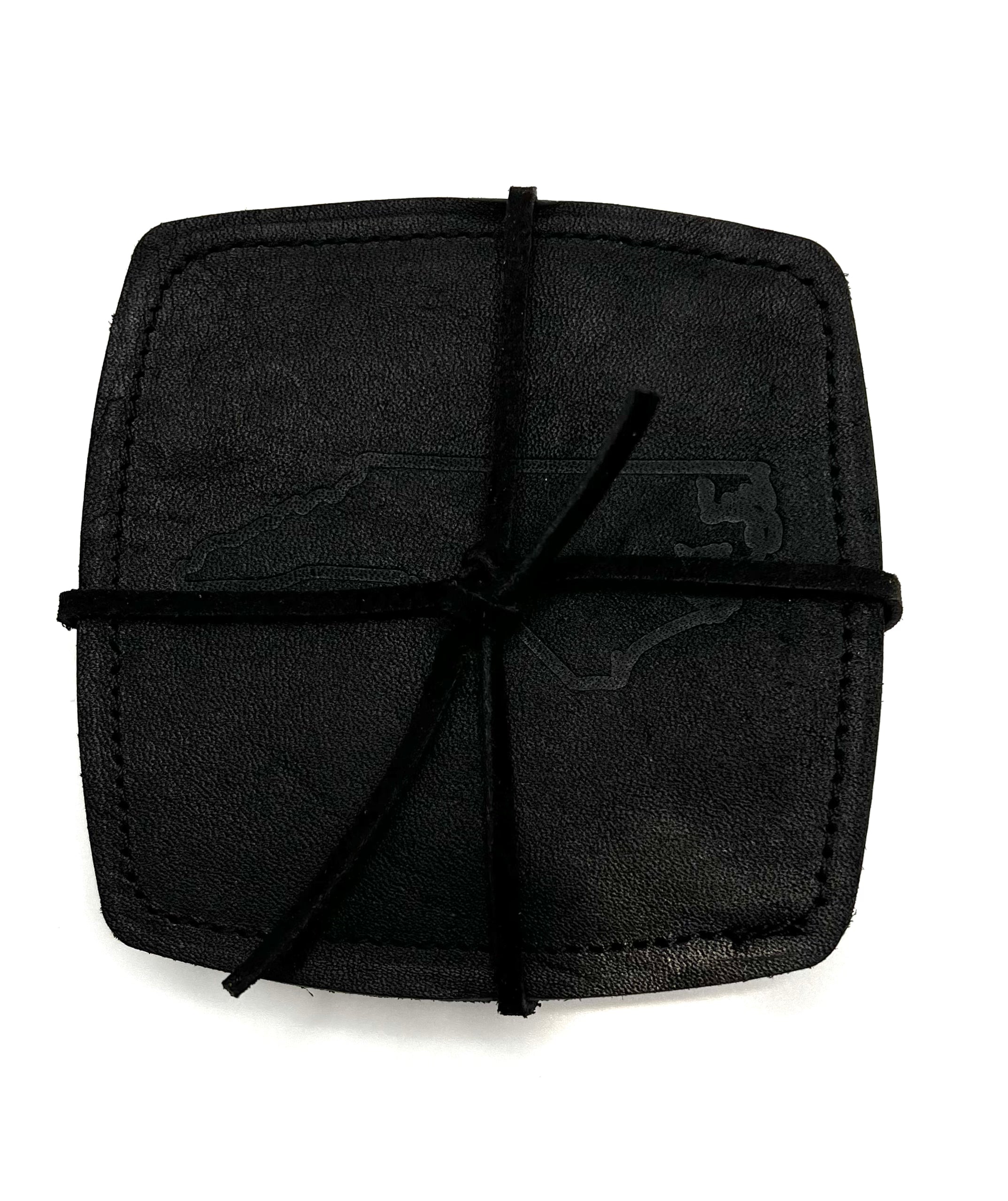 Black leather coaster with an NC state outline stamped in the center, tied together with leather lacing, displayed on a white background