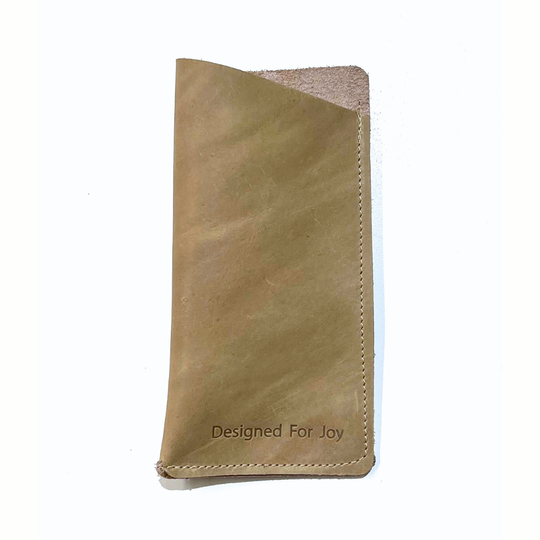 Tan slim eyeglass case with a suede interior and angled top design, displayed on a white background