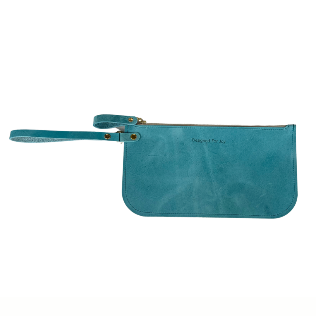 Aqua blue slim zipper wristlet with 'Designed for Joy' text, displayed on a white background