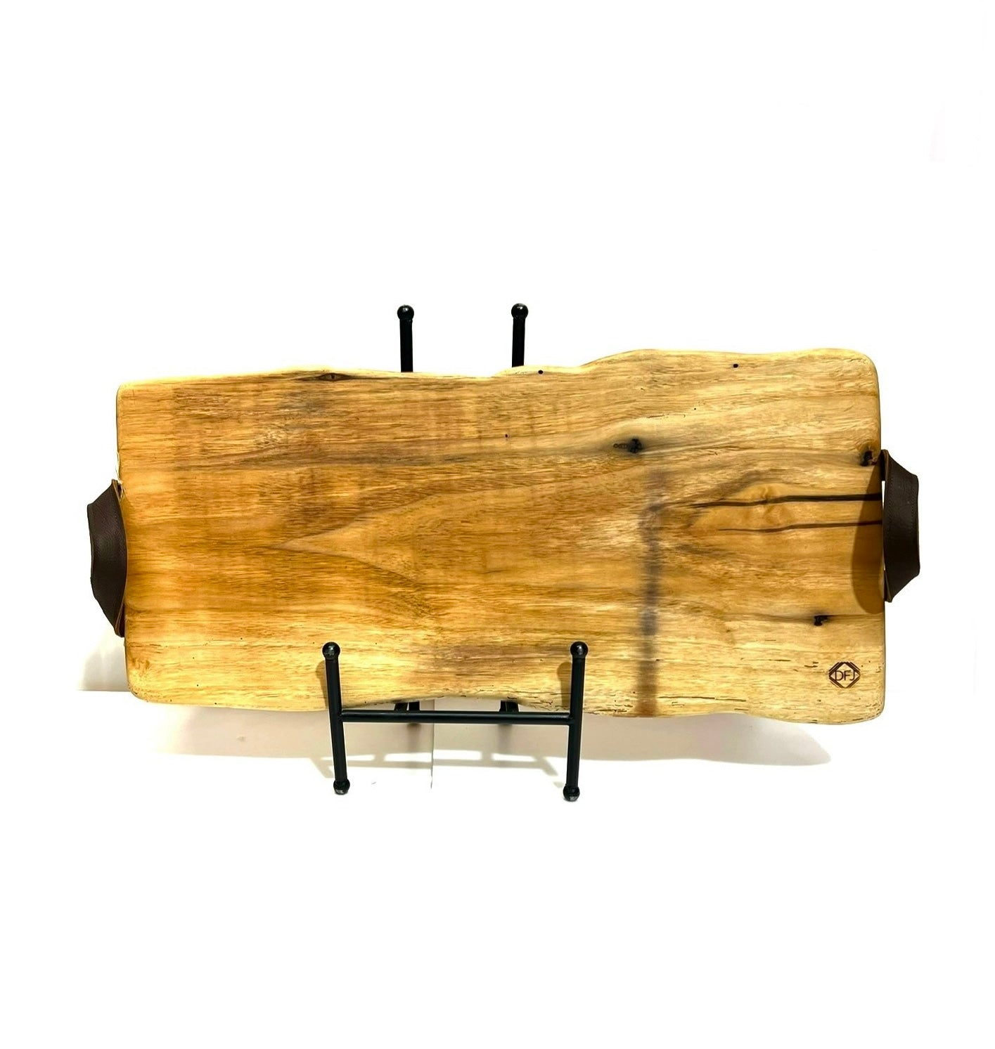 A live-edge charcuterie board made of maple wood with leather handles