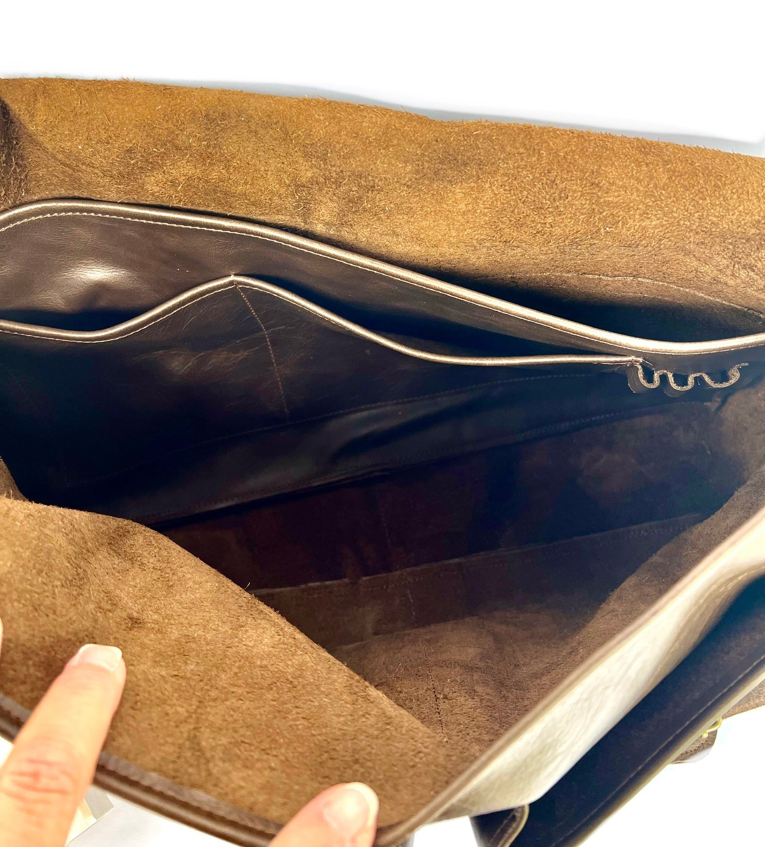 Inside a professional messenger/laptop bag featuring a suede interior with fingers opening it up