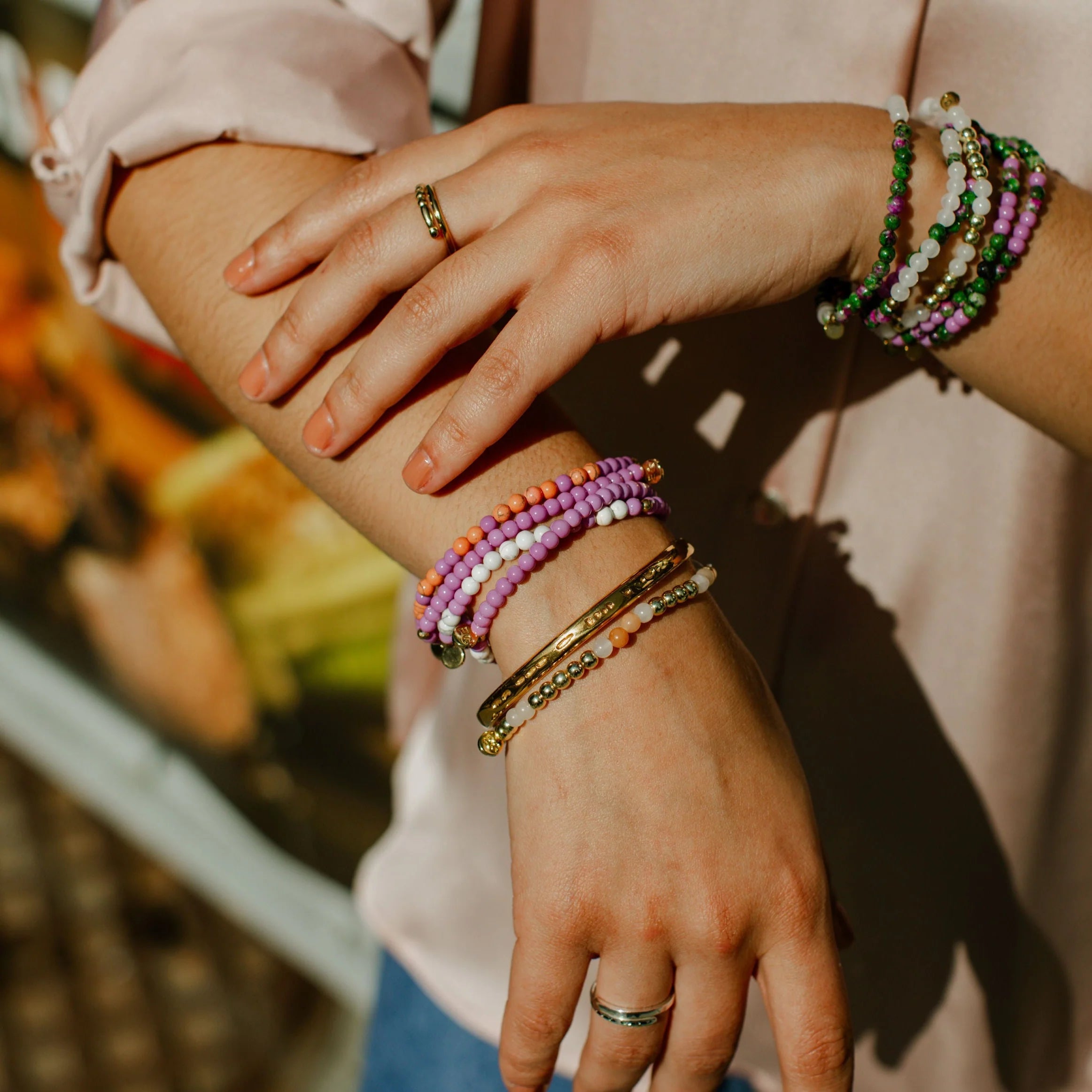 Close up of a person's wrist wearing multiple-colored bracelets