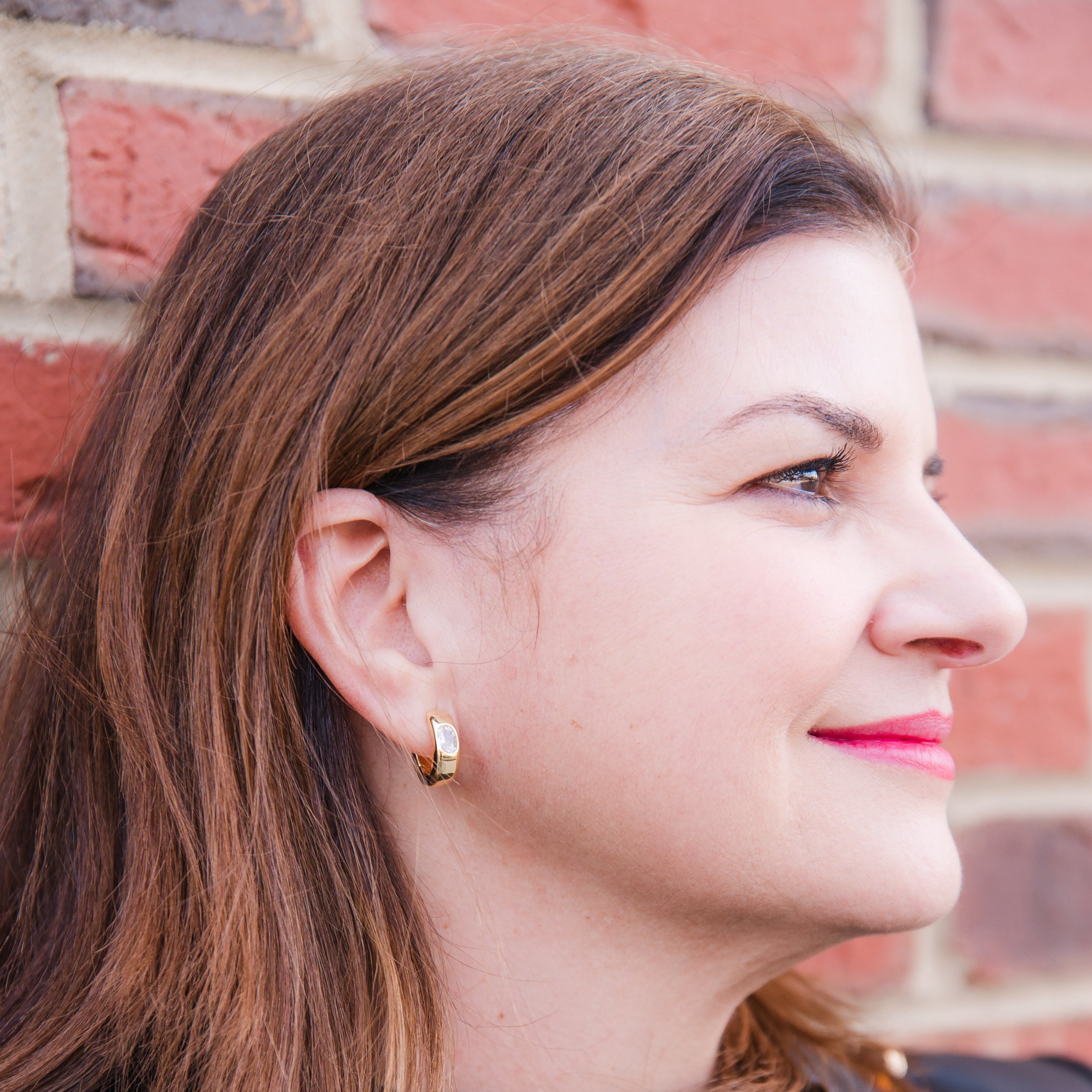 Person wearing a silver cubic zirconia hoop earring