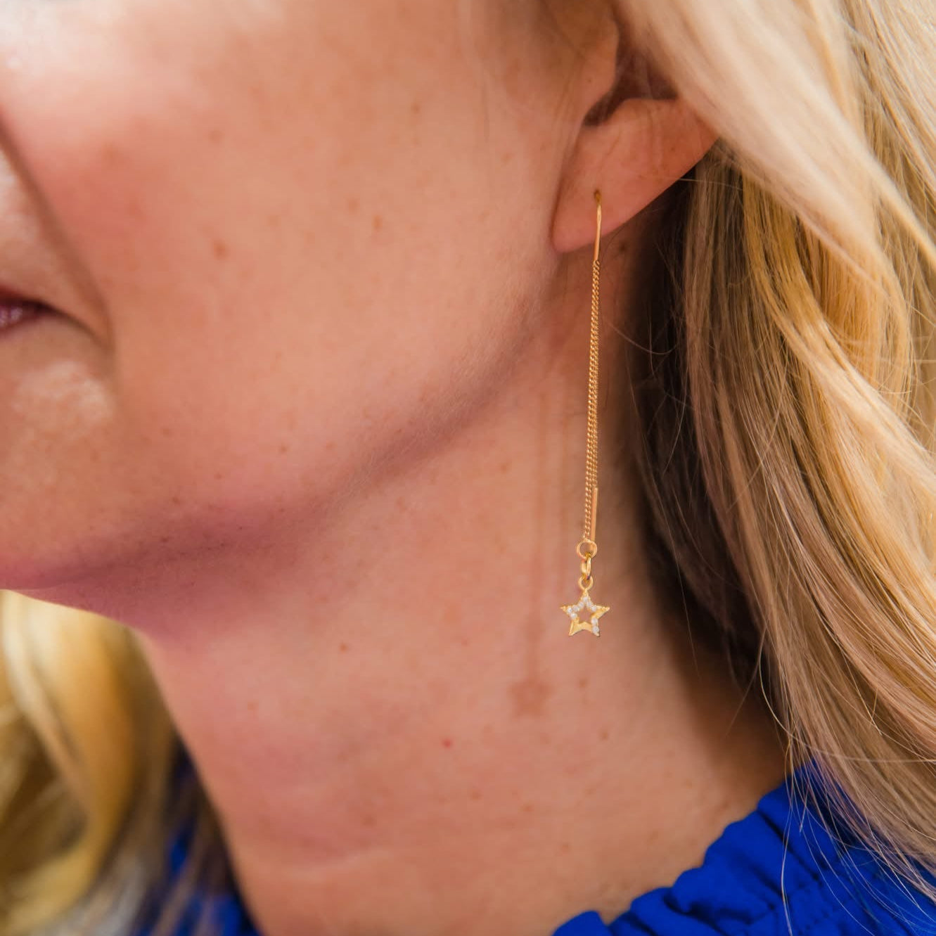 Close-up of a person wearing shooting star earrings