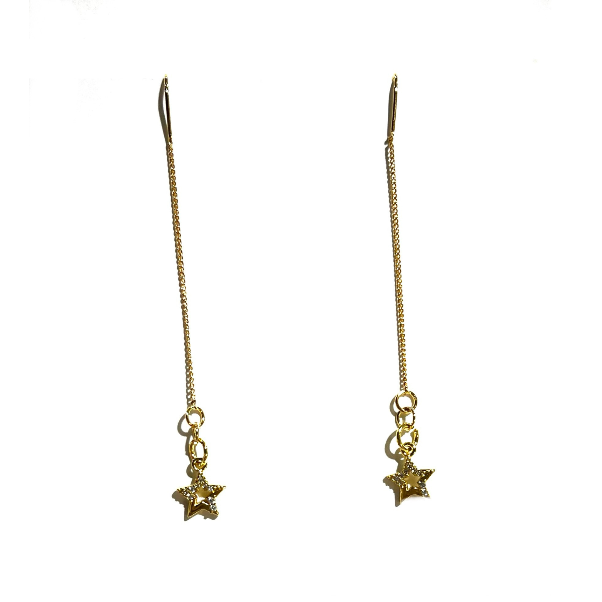 A pair of gold-plated threader earrings with shooting star charms attached to the end of the chain, displayed on a white background