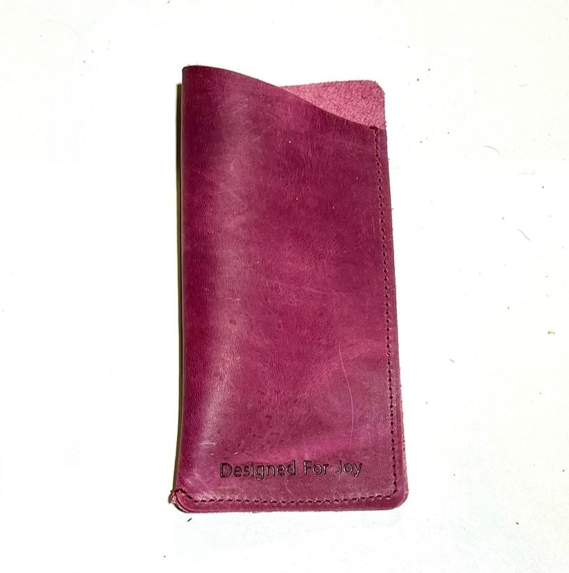 Raspberry pink slim eyeglass case with a suede interior and angled top design, displayed on a white background