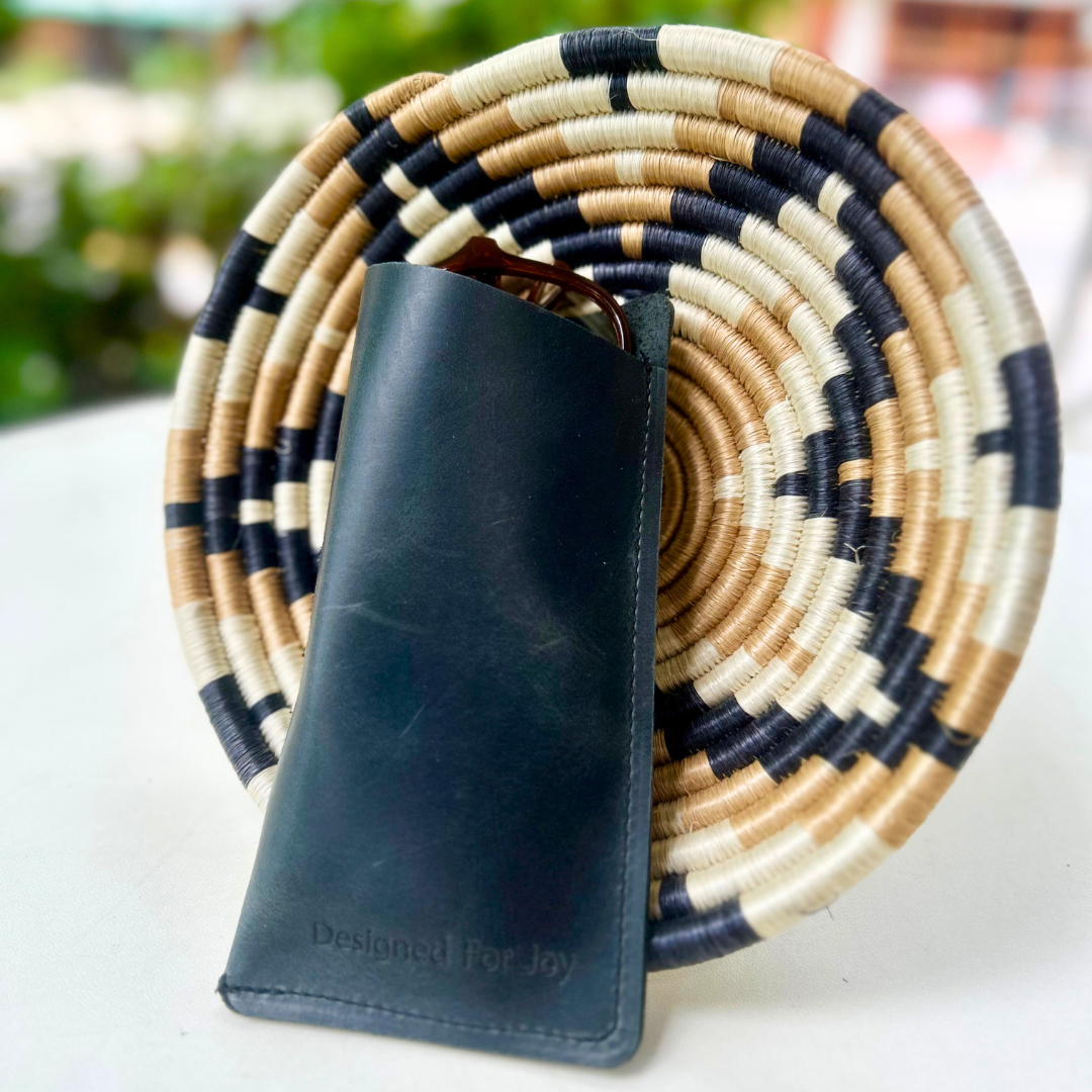 Black slim eyeglass case leaning against a basket in an outdoor setting