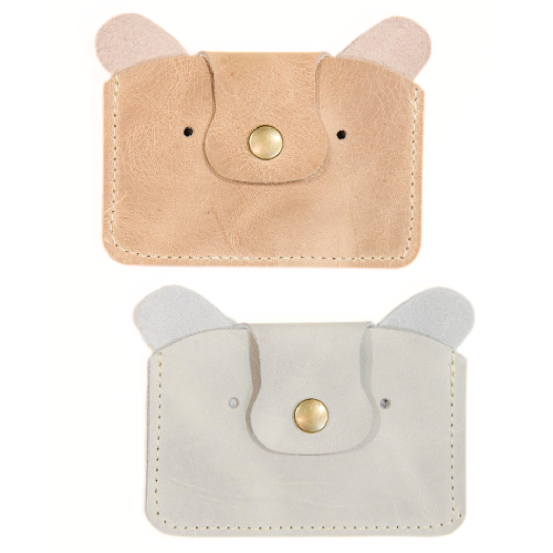 Two leather card wallets designed to resemble teddy bears with ears protruding from the top and a snap closure at the front, in colors tan and gray