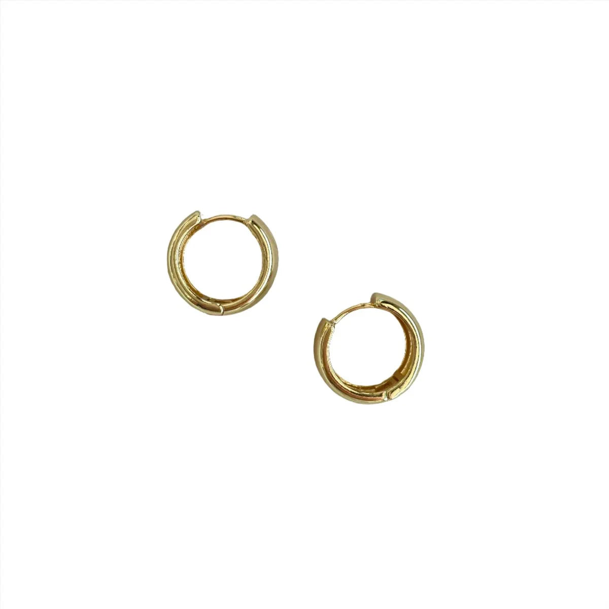 Pair of gold-colored wide mini hoop earrings laying on their side, on a white background