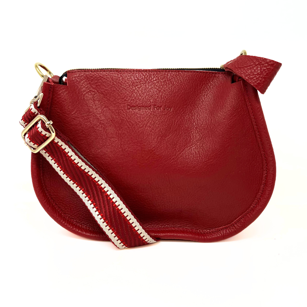 Red pebbled leather crossbody handbag with a smooth, chunky zipper and a crossbody strap
