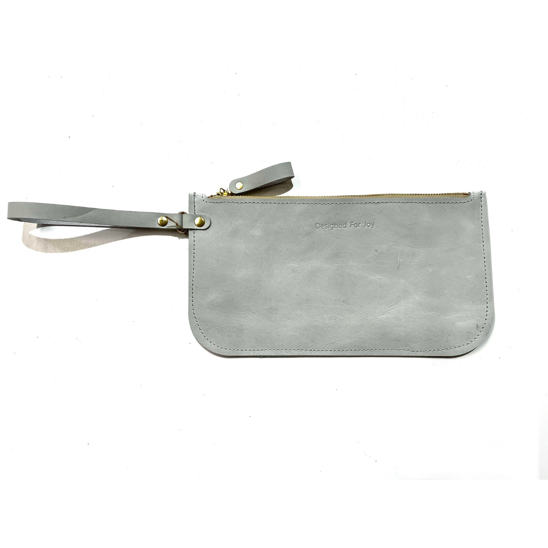 Gray slim zipper wristlet with 'Designed for Joy' text, displayed on a white background