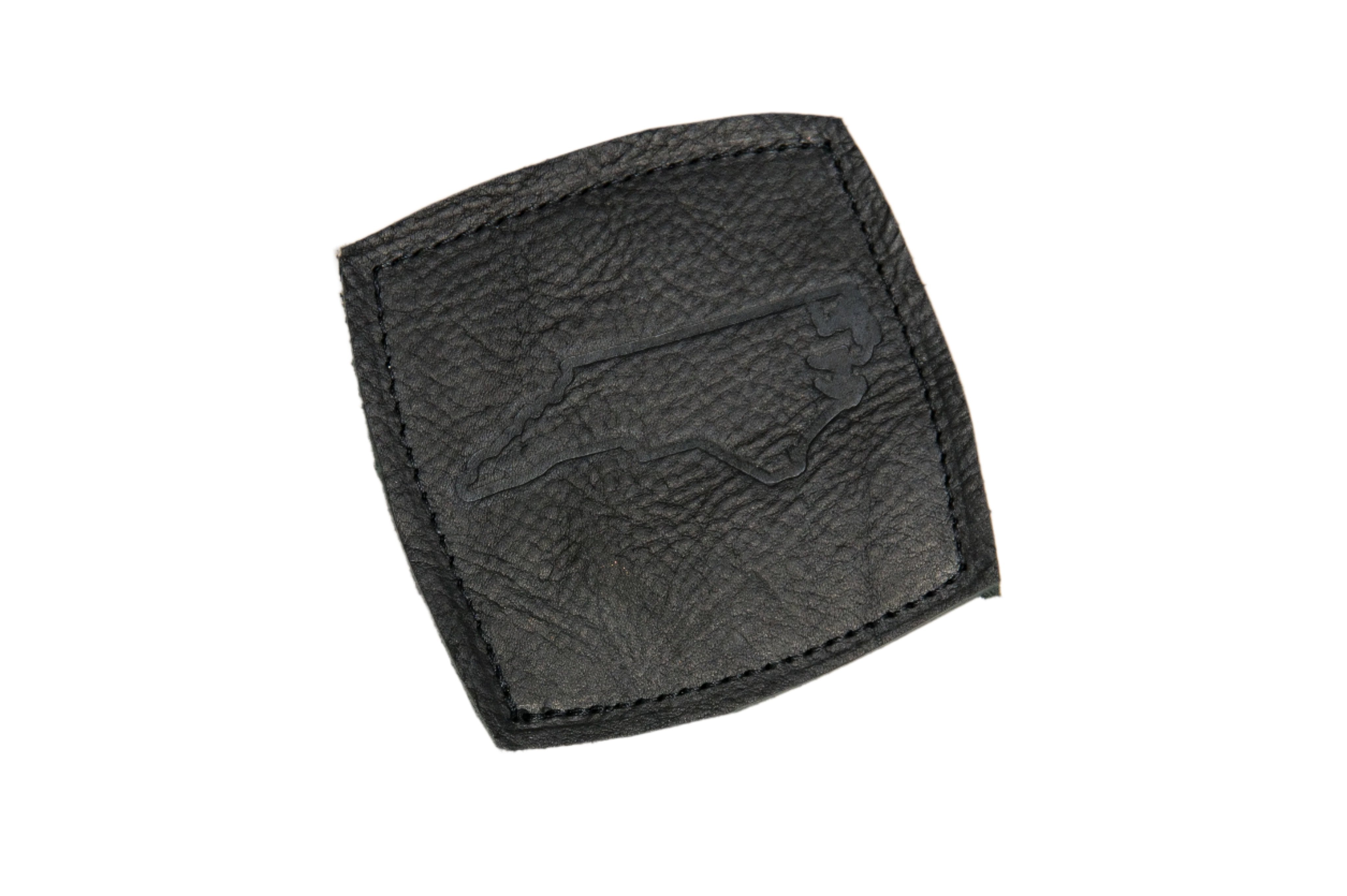 Black leather coaster with an NC state outline stamped in the center, displayed on a white background