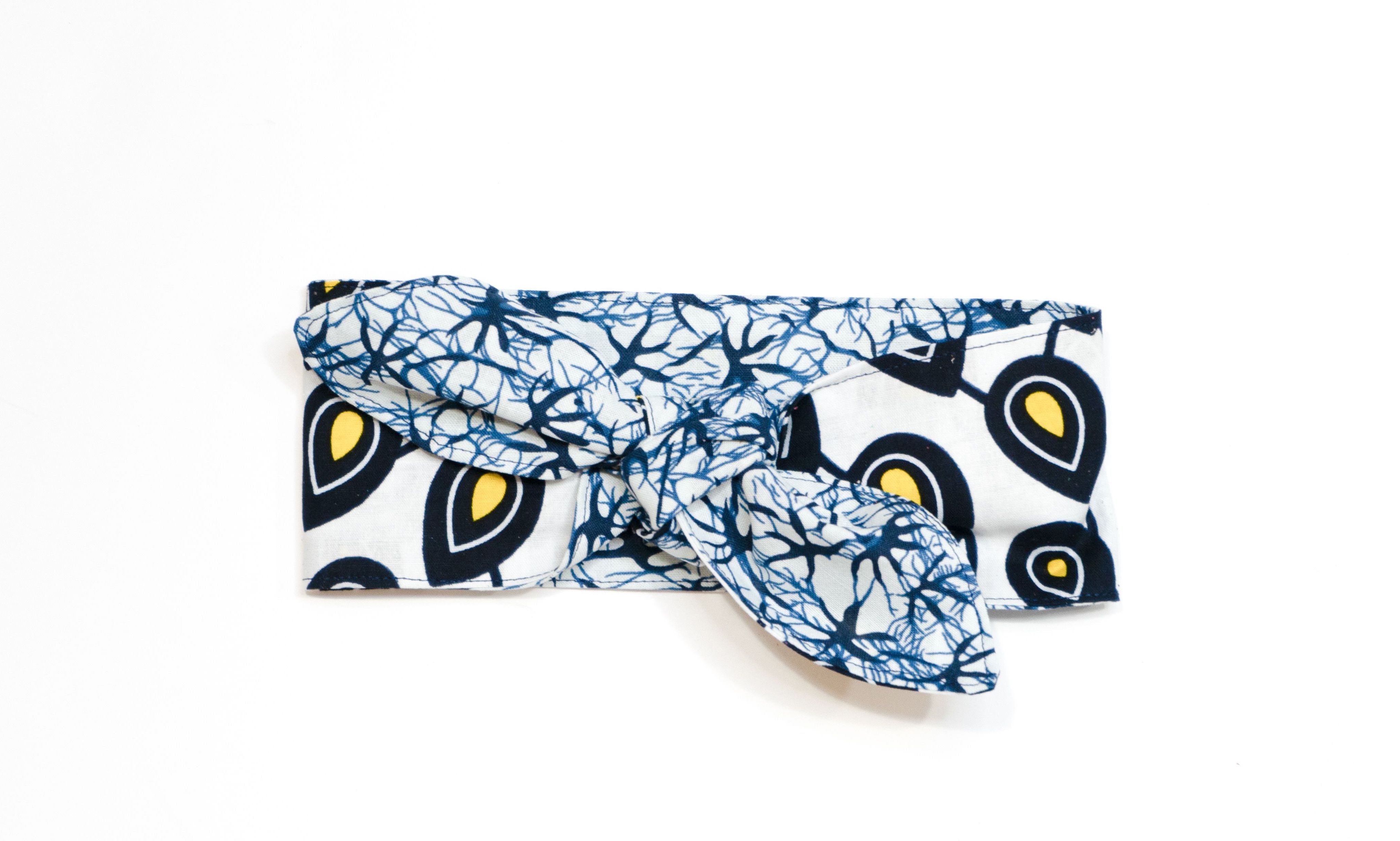 Reversible head wrap with a gold and navy pattern on one side and a blue pattern on the other, displayed on a white background