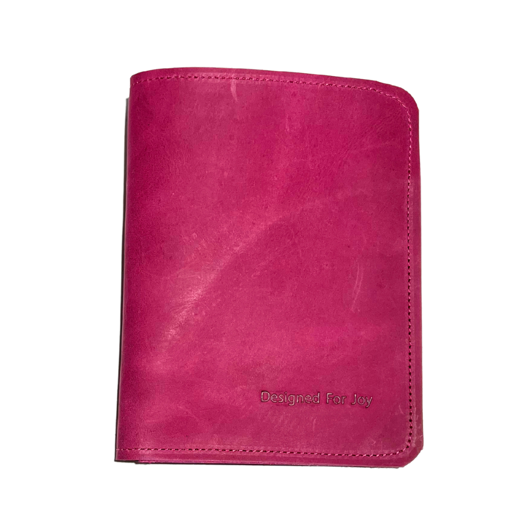 Pink card holder with 'Designed for Joy' text on a white background