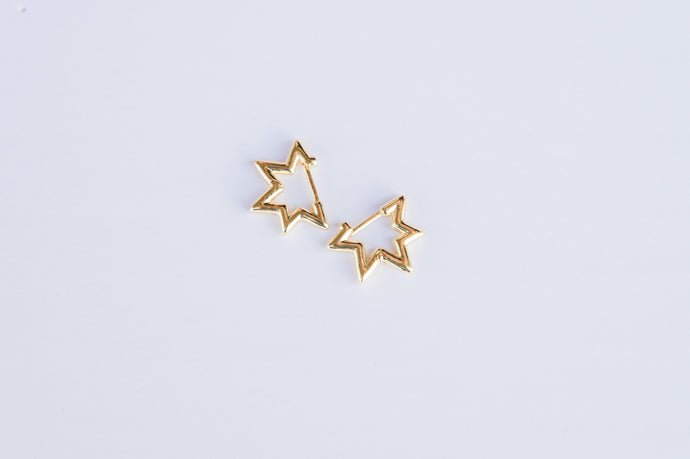 Gold star huggie style earrings.