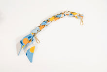 Gold scarf chain with blue, yellow and orange fruit for purse.